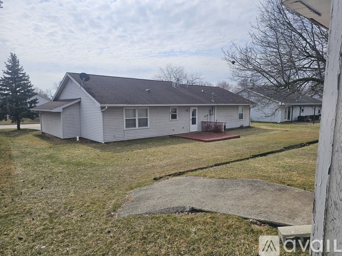 A house with a grey roof and a small front yard.