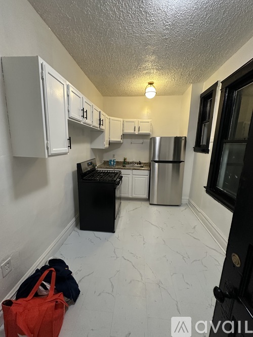A kitchen with white cabinets and a black dishwasher.