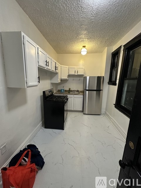 A kitchen with white cabinets and a black dishwasher.
