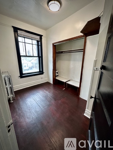 A room with a ceiling fan and a window with a radiator beneath it.