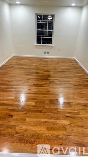 A room with wooden flooring and a window.