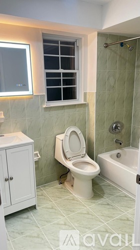 A bathroom with a toilet, sink, and bathtub.
