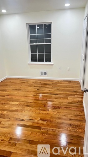 A room with wooden flooring and a window.