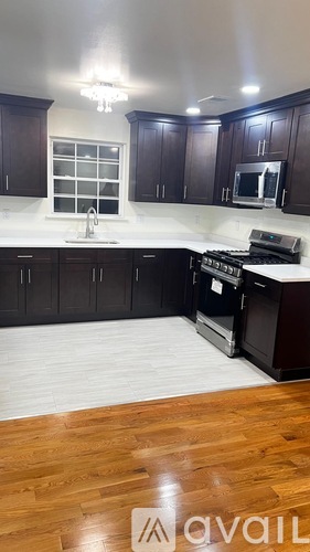 A kitchen with dark wood cabinets and a white countertop.