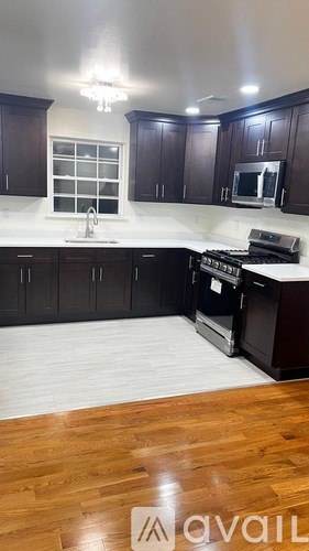 A kitchen with dark wood cabinets and a white countertop.