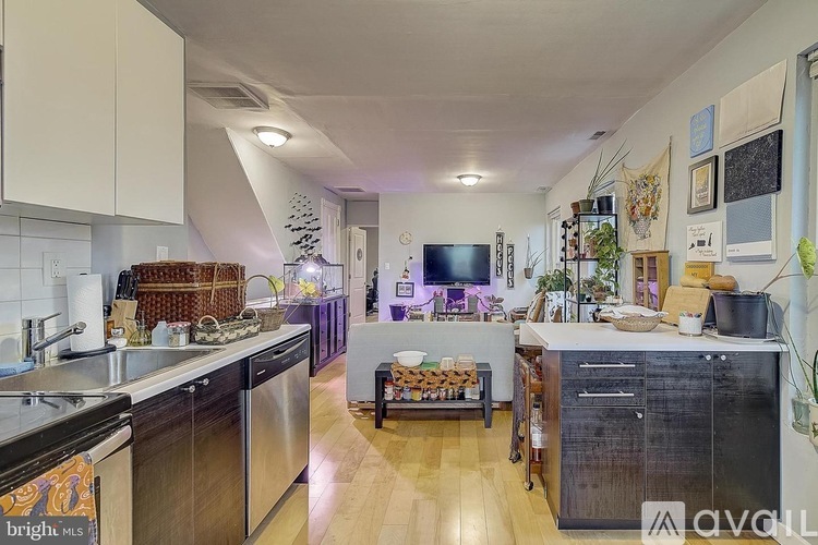 A kitchen with a black fridge and wooden floors.