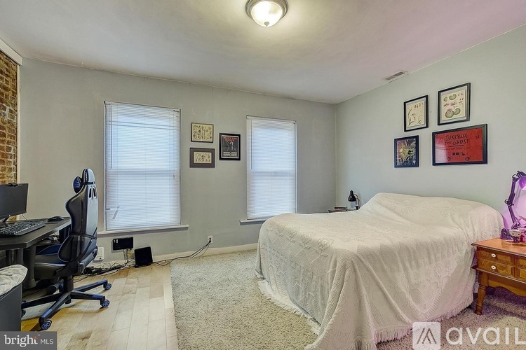 A bedroom with a bed, desk, and chair.