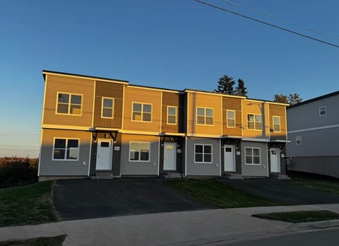 A row of houses with a clear blue sky above them.
