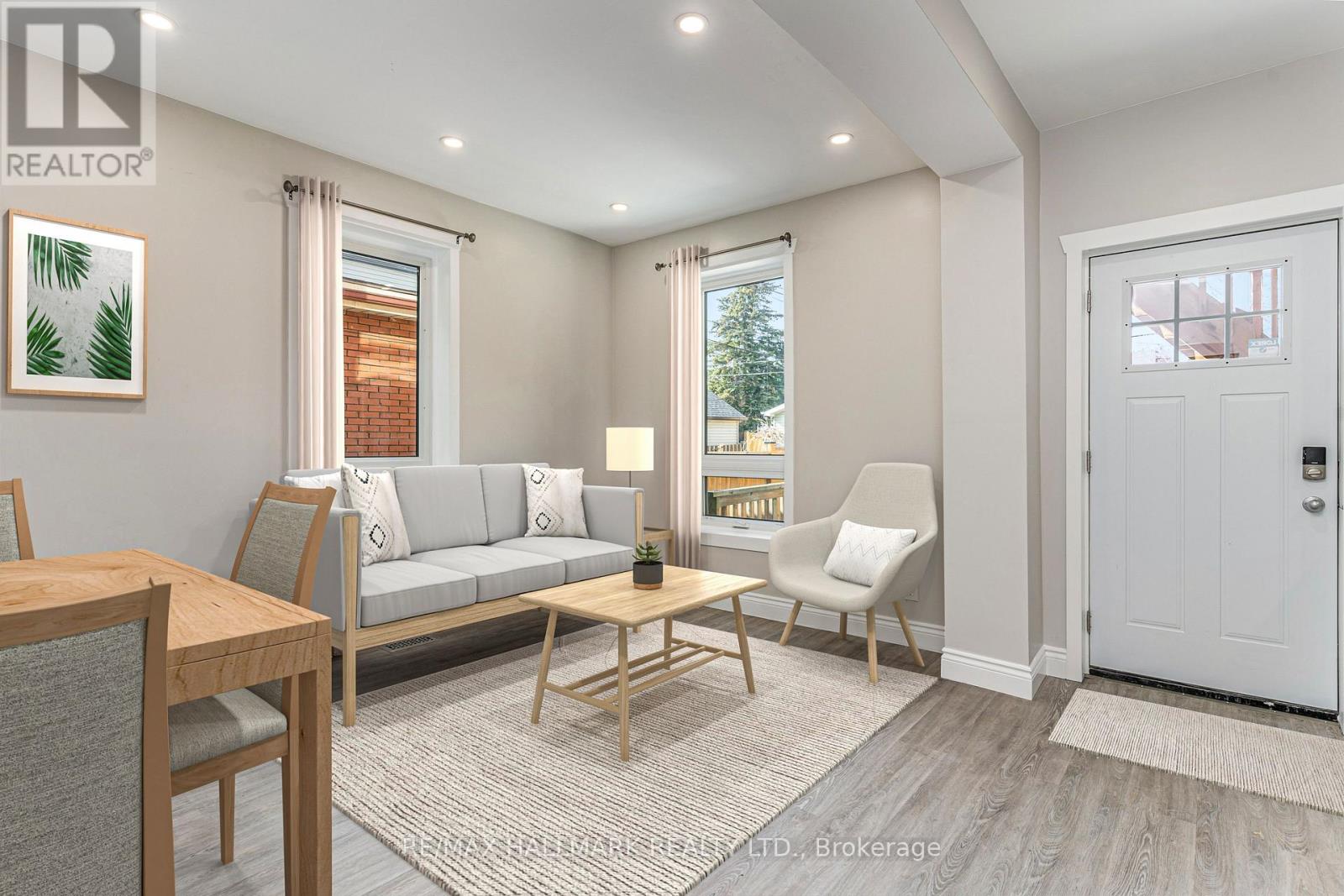 A well-lit living room with a grey sofa, a wooden coffee table, and a white door.