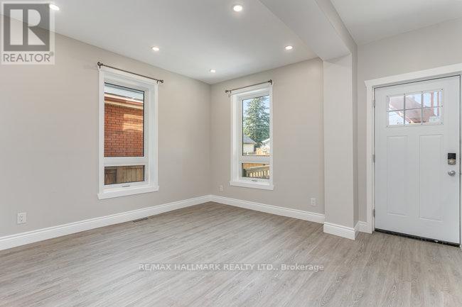 A spacious room with a white door and a window with blinds.