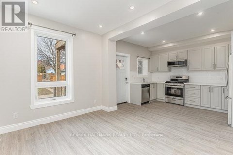 A well-lit kitchen with white cabinets and a large window.