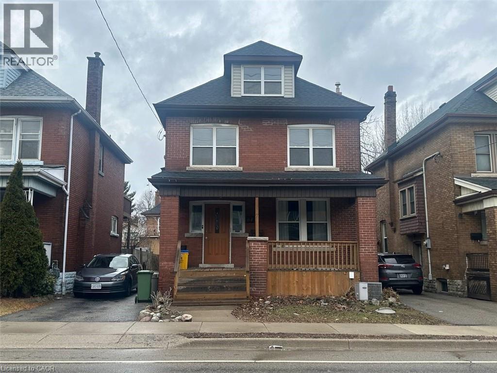 A two-story brick house with a brown front door and a wooden fence.