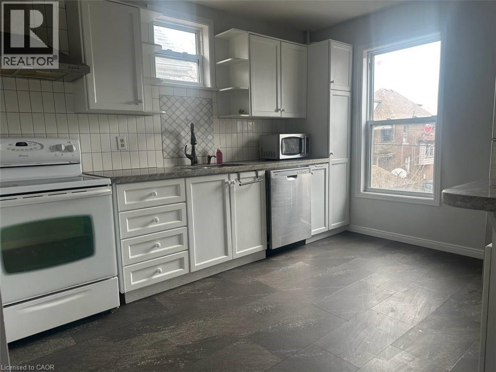 A kitchen with white appliances and cabinets.