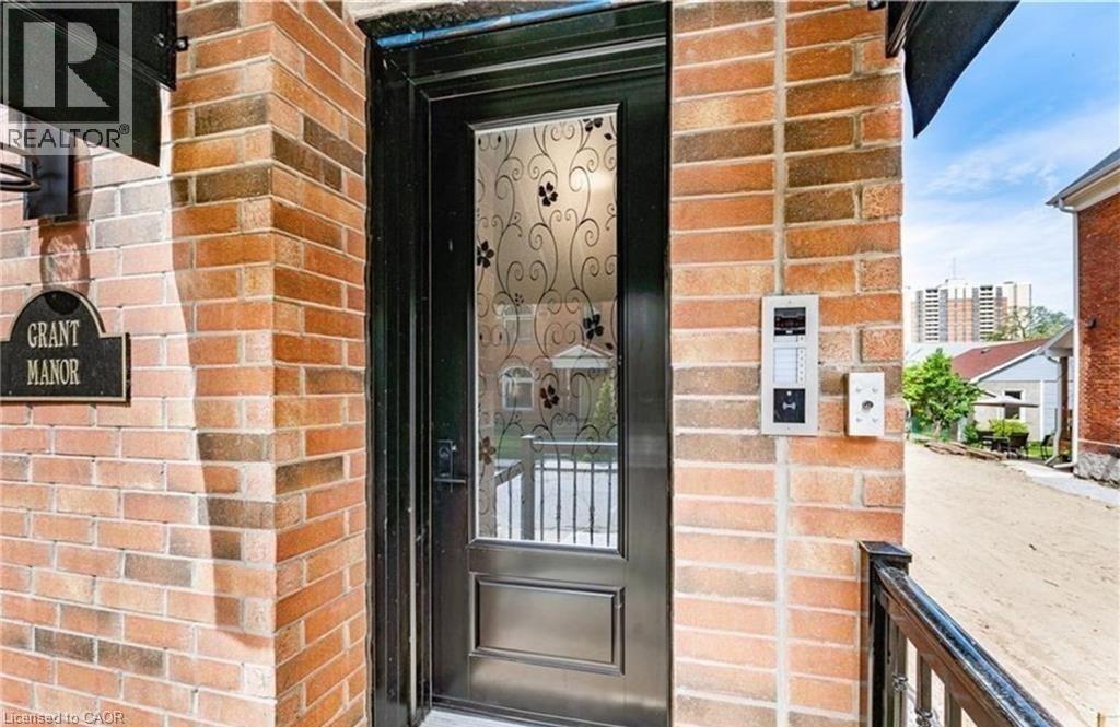 A brick building with a door and a sign that says Grant Manor.