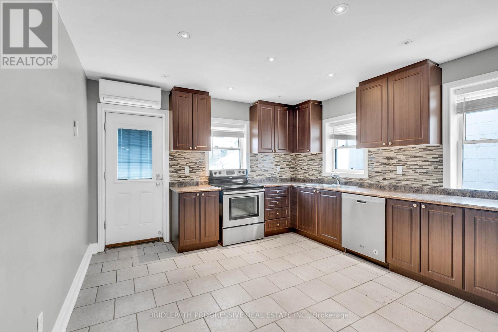 A kitchen with brown cabinets and a white door.