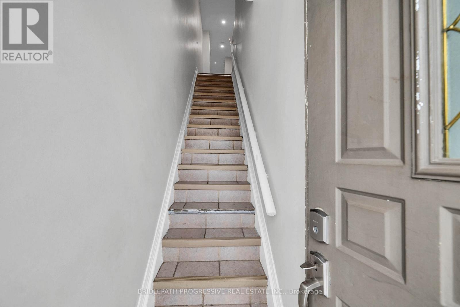 A staircase with a wooden handrail and treads leading upwards.