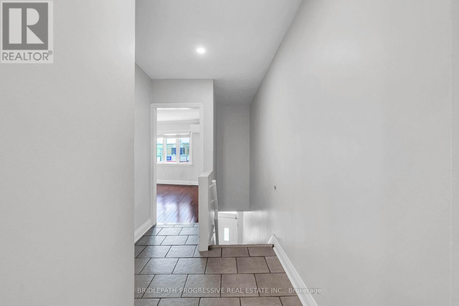 A hallway with a tiled floor and white walls.