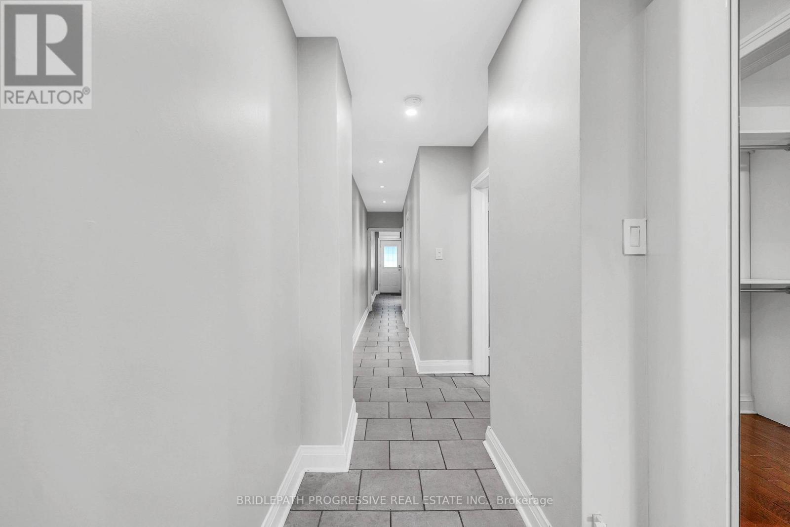 A hallway with a brick floor and white walls.