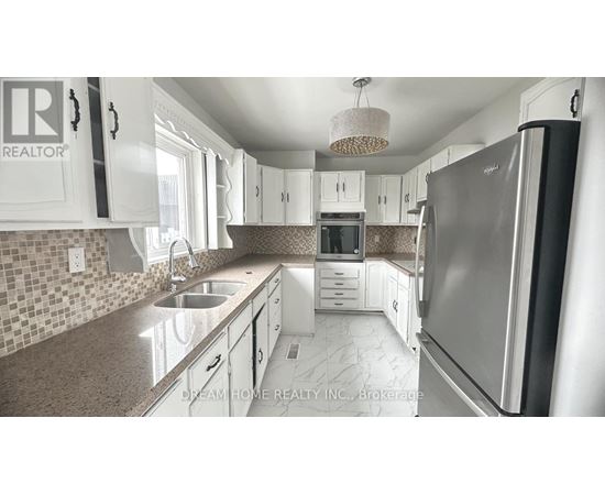 A kitchen with a refrigerator, sink, and cabinets.