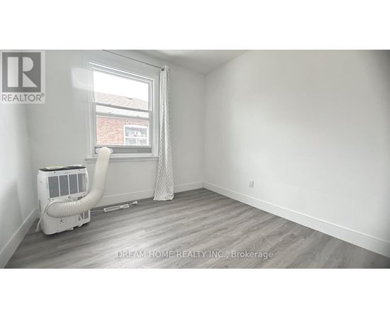 A room with a window, a fan, and a white air conditioner.