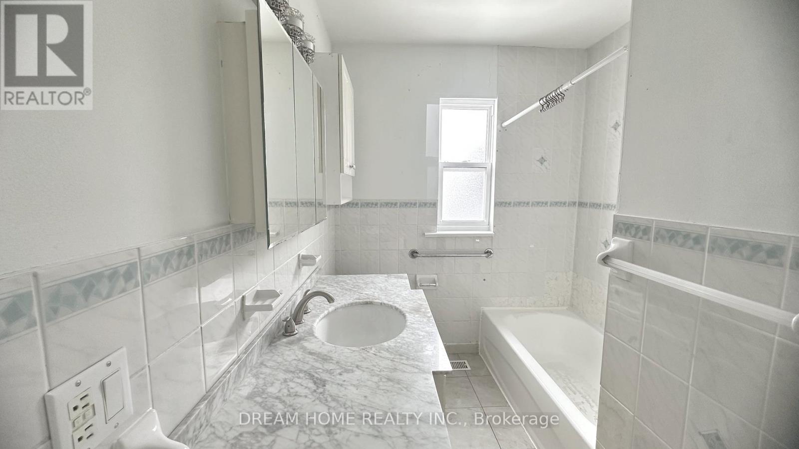 A bathroom with a marble countertop and a window.