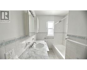 A bathroom with a marble countertop and a window.