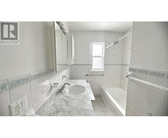 A bathroom with a marble countertop and a window.