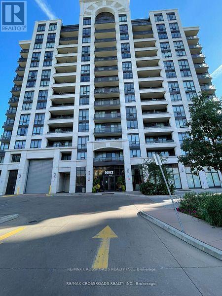 A tall apartment building with a yellow arrow on the street in front.