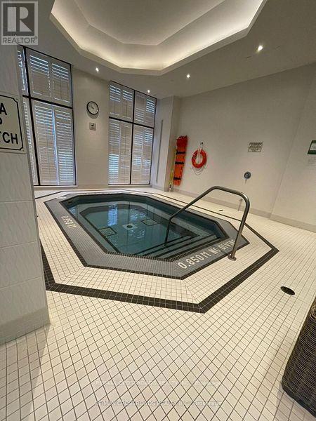 A swimming pool in a room with white tiles.