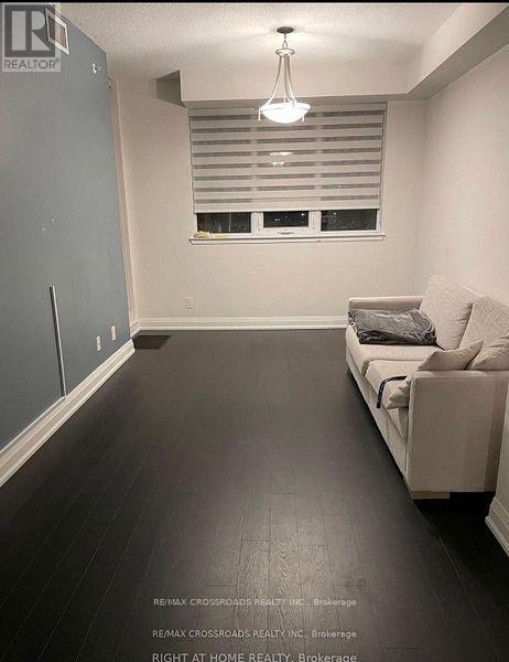 A living room with a couch and a window with blinds.