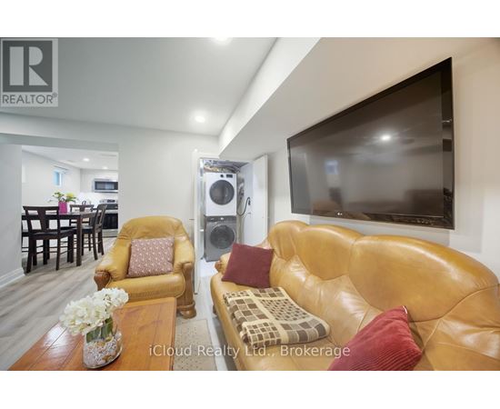 A living room with a brown leather couch and a flat screen TV mounted on the wall.