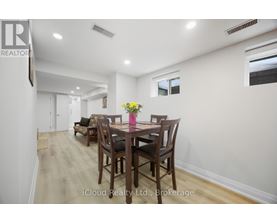 A dining room with a table set for two with a vase of flowers on the table.