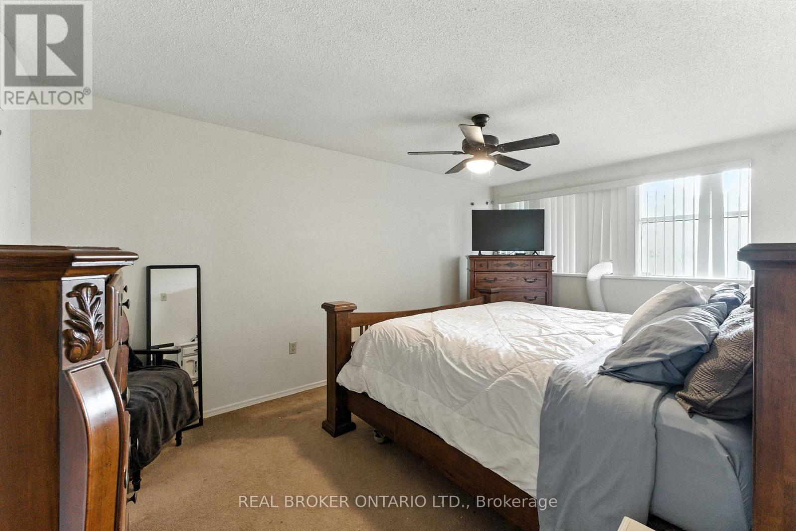 A bedroom with a bed, dresser, and mirror.