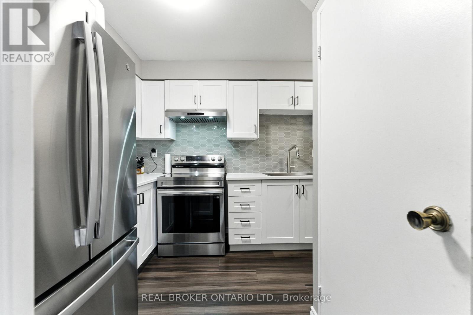 A modern kitchen with white cabinets and stainless steel appliances.