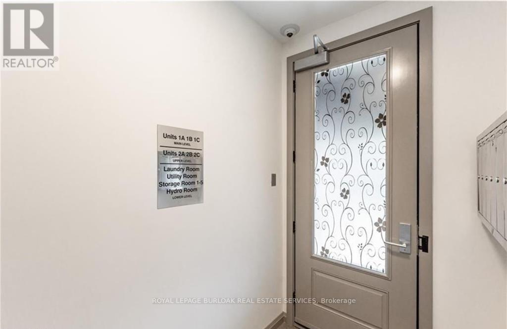 A door with a glass window and a sign on the wall.