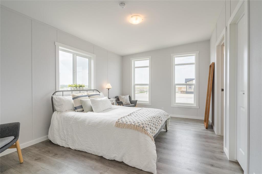 A bedroom with a large bed and a chair.