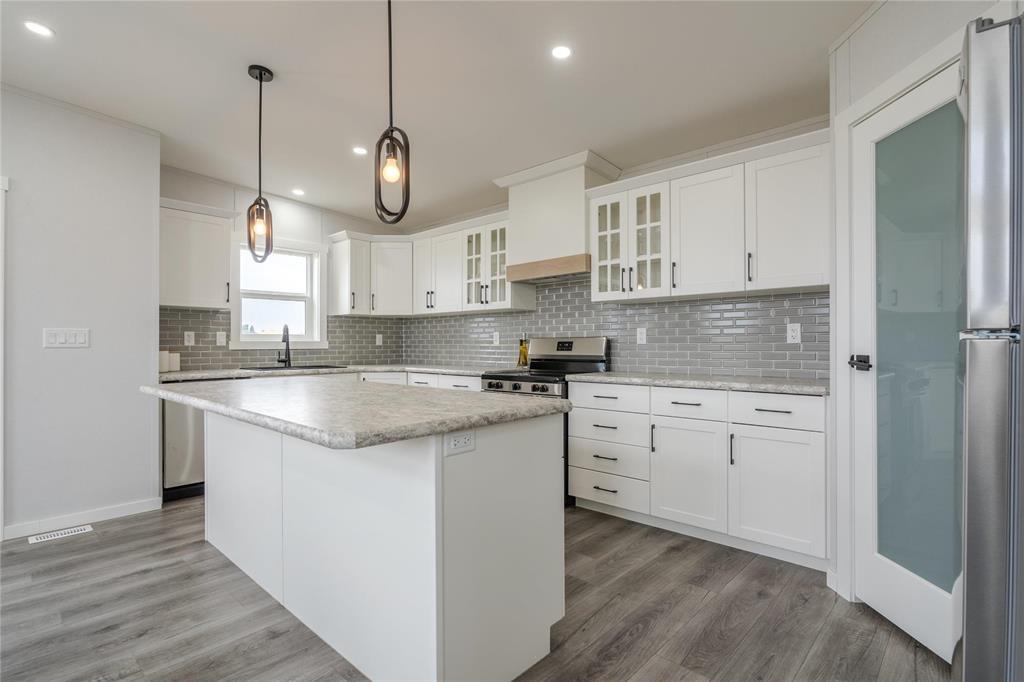 A kitchen with white cabinets and a marble countertop.