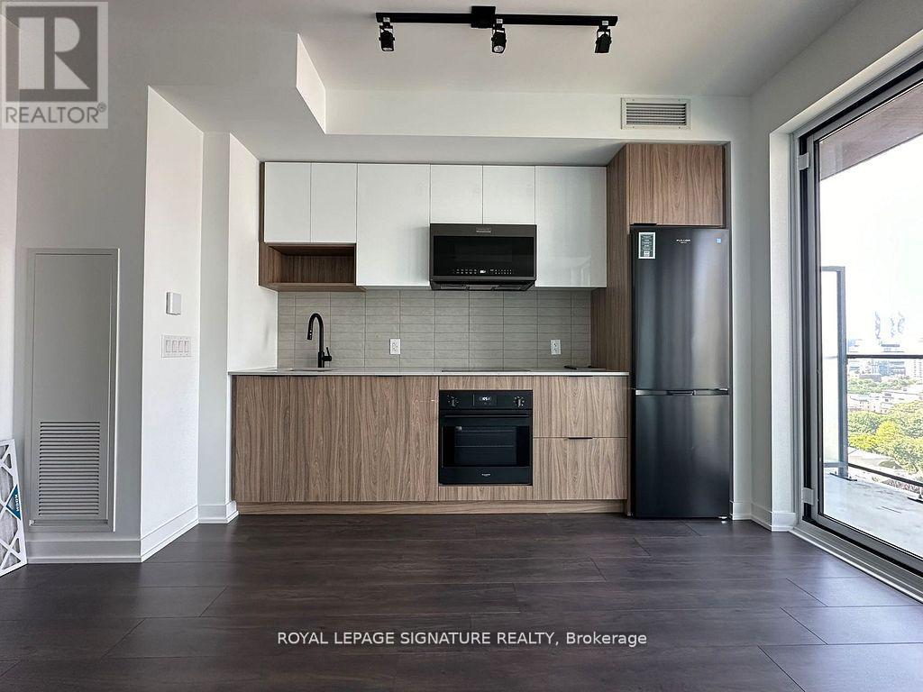 A modern kitchen with wooden cabinets and black appliances.