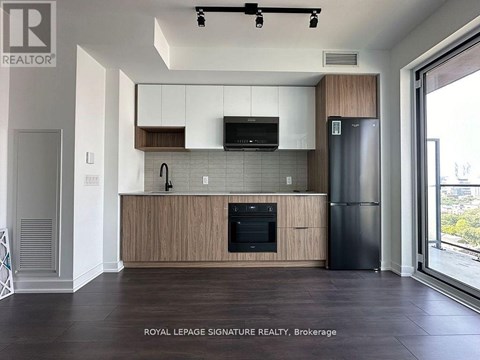 A modern kitchen with wooden cabinets and black appliances.