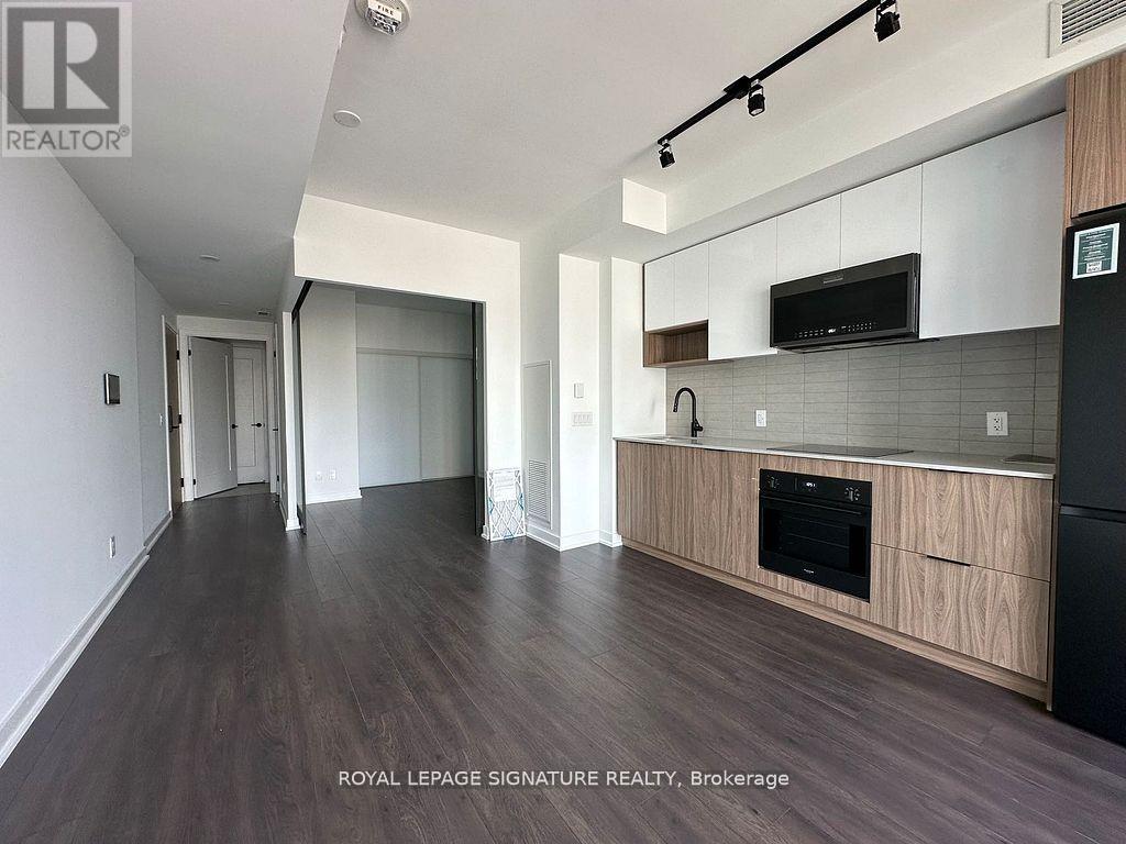 A spacious kitchen with wooden cabinets and a black oven.