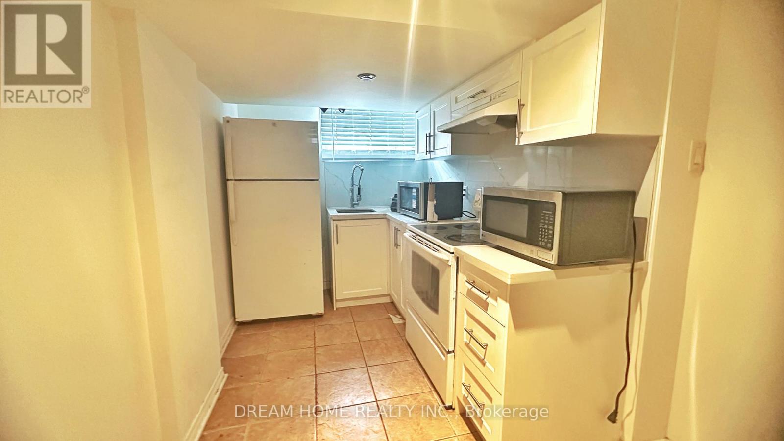 A kitchen with white appliances and cabinets.