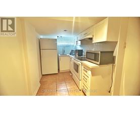 A kitchen with white appliances and cabinets.