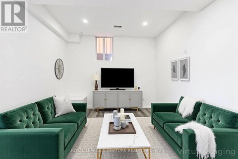 A living room with green velvet sofas and a white coffee table.