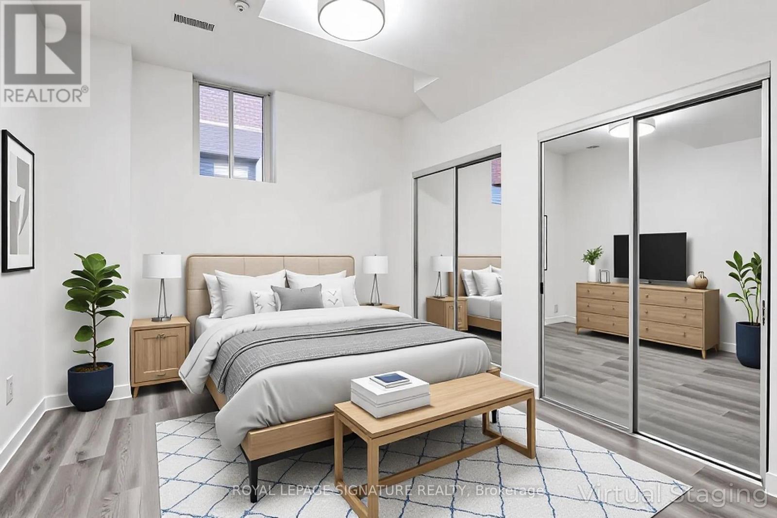 A bedroom with a large bed and a wooden nightstand.
