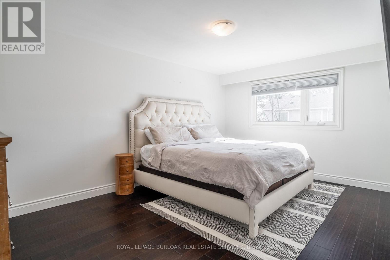 A bedroom with a large bed and a wooden floor.