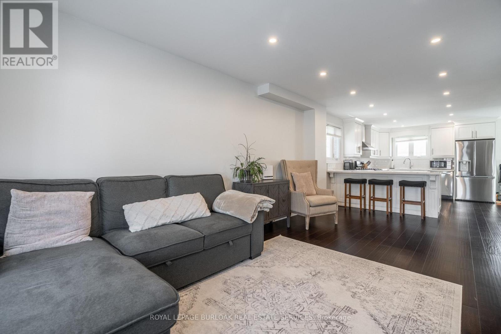 A living room with a grey sofa and a rug.