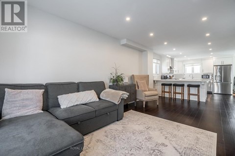 A living room with a grey sofa and a rug.