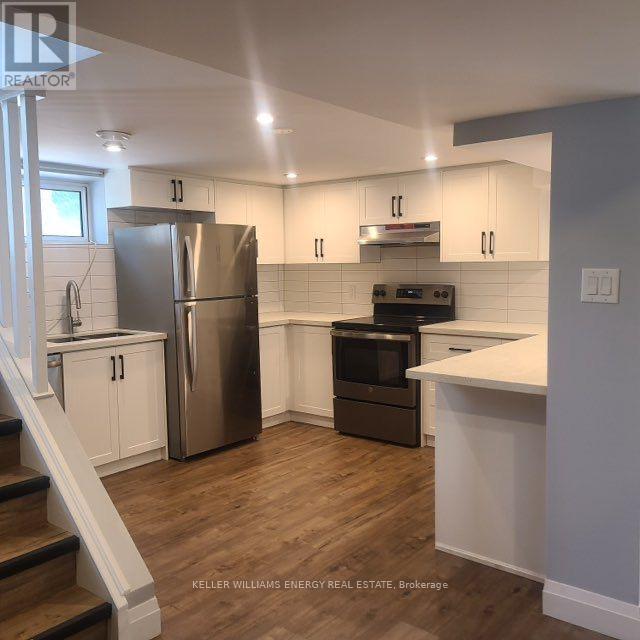 A kitchen with a stainless steel refrigerator and oven, and a white countertop.