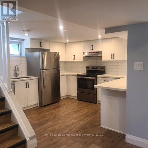 A kitchen with a stainless steel refrigerator and oven, and a white countertop.