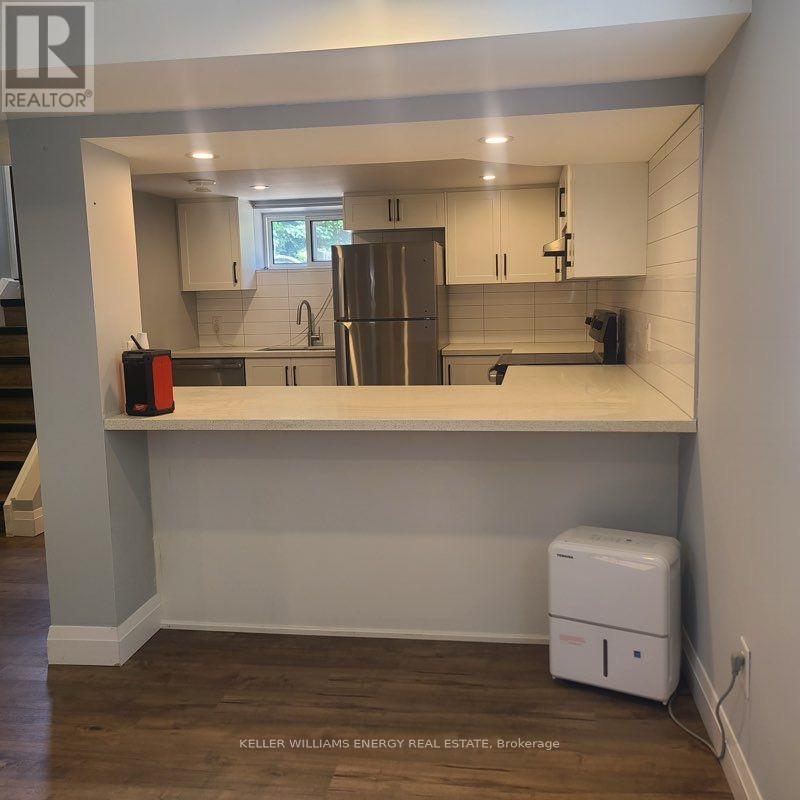 A kitchen with a refrigerator, a sink, and a counter.